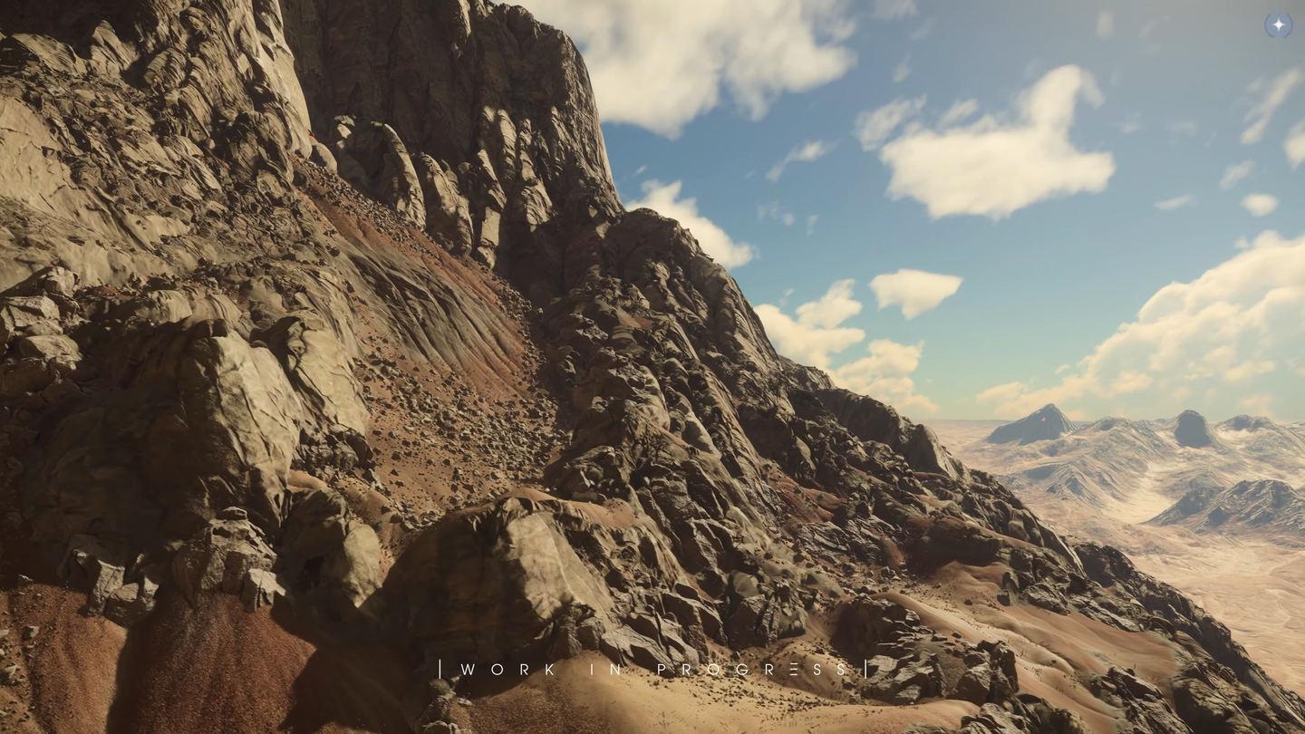 Boulders and smaller stones cover reddish slopes beneath a large cliff, with mountains in the distance.
